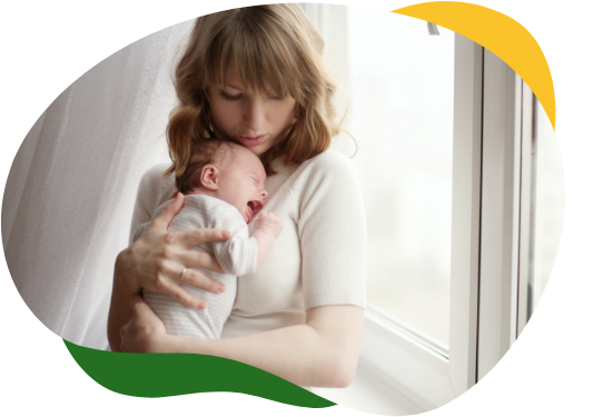 A young mother presses her crying baby to her chest to soothe it from baby colic